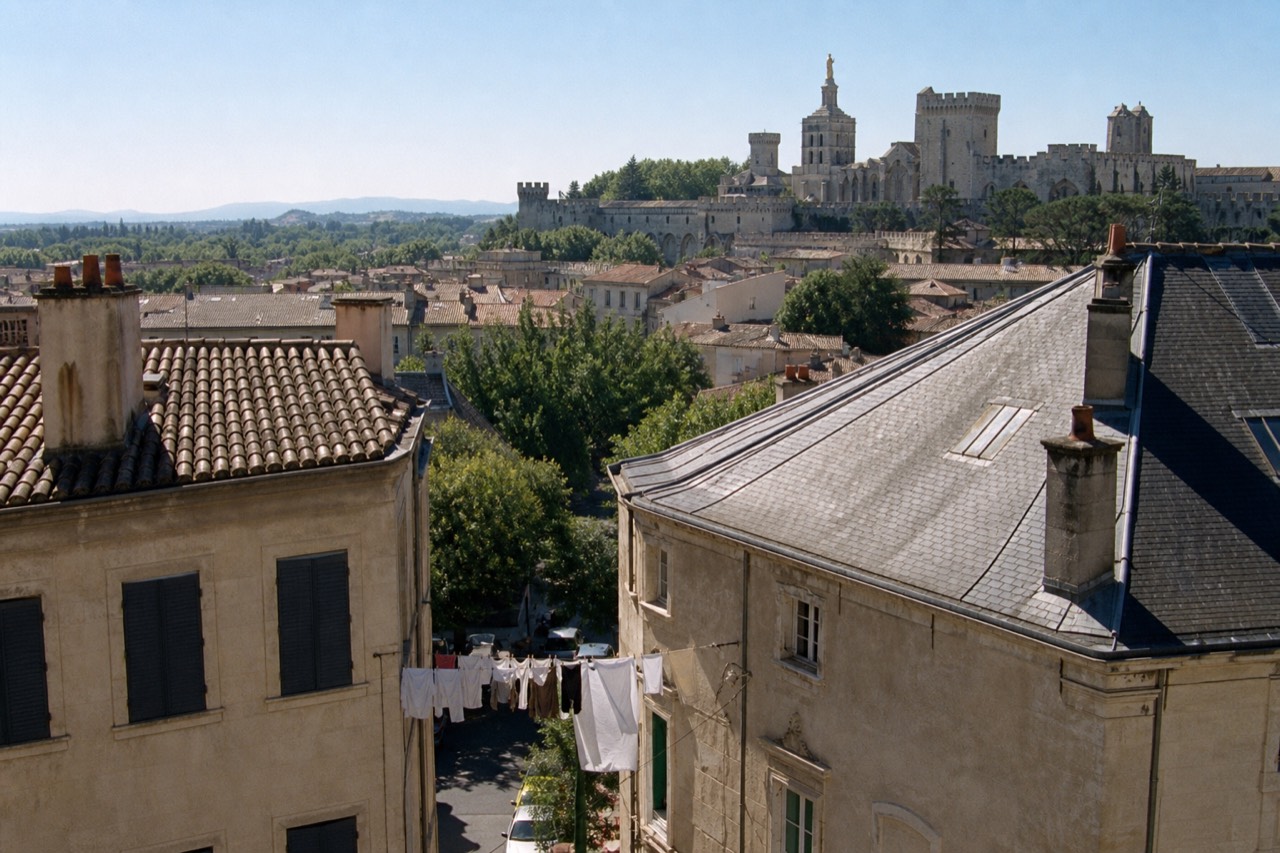 The ramparts and rooftops of Avignon under a clear sky, no text, no logos, no people.