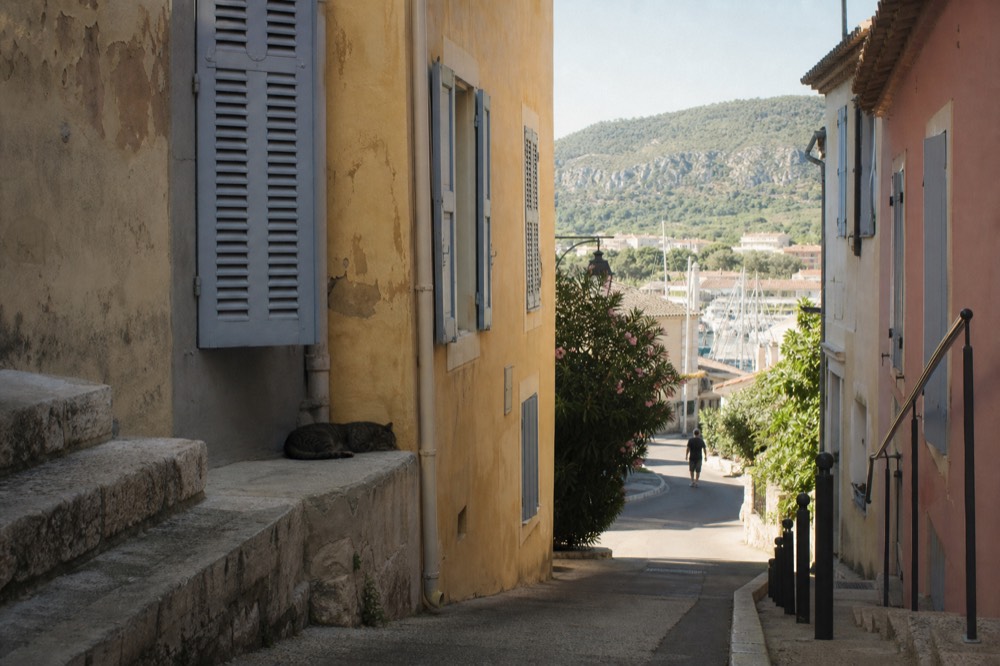 A quiet street in Cassis with shuttered houses near the harbour, no text, no logos, no people