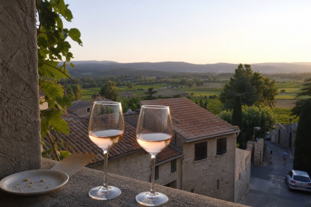 Glasses of pale rosé on a stone terrace overlooking vineyards near Aix-en-Provence, no text, no logos, no people