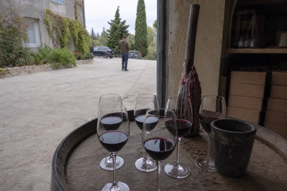 Cellar door tasting glasses lined on a wooden barrel top in a Coteaux d'Aix winery, no text, no logos, no people