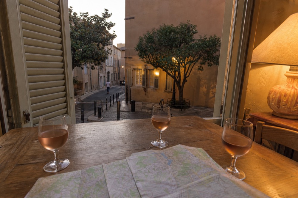 Map and wine glasses on a tasting table in Aix, no text, no logos, no people