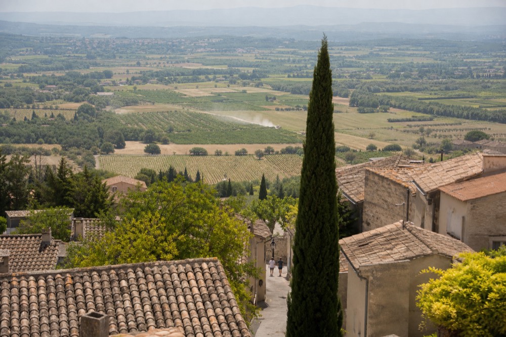 Hilltop Luberon village above vineyards and cherry orchards, no text, no logos, no people