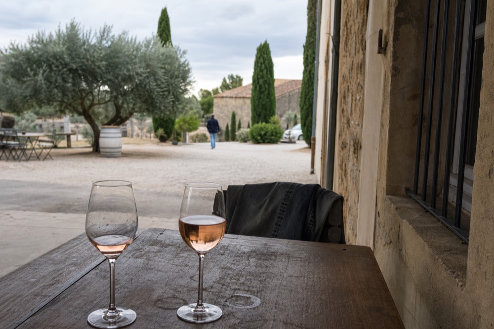 Two glasses of pale rosé wine on a wooden tasting table, no text, no logos, no people