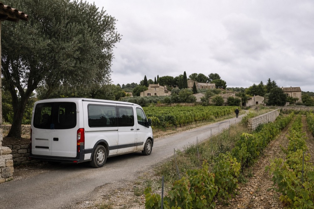 A small van parked on a country lane beside vineyard rows, no text, no logos, no people