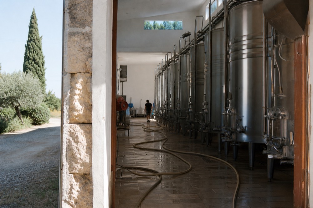 Stainless steel fermentation tanks inside a bright Provençal winery, no text, no logos, no people