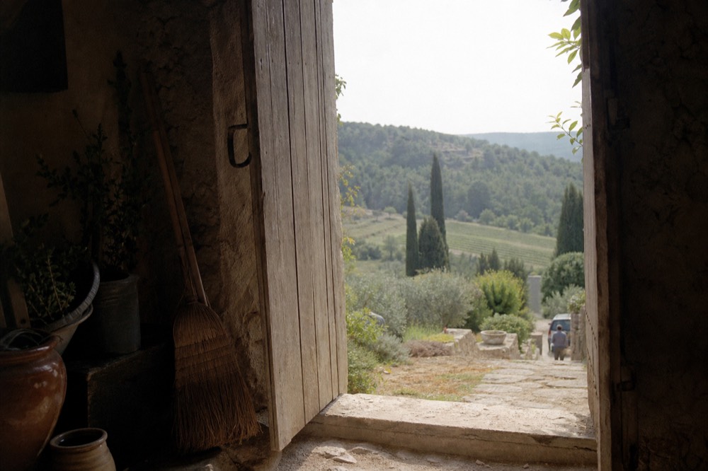 A cellar door on a Provence hillside with vines and cypress trees, no text, no logos, no people