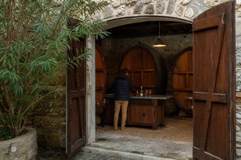 A cellar door with barrels and a tasting counter, no text, no logos, no people